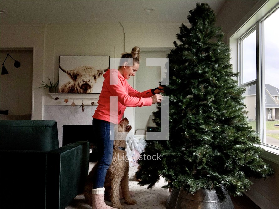 woman decorating a Christmas tree 