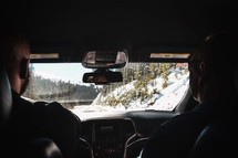 man driving a car through snow 