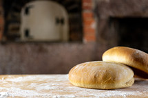 Round bread loaves on a floured board in old kitchen