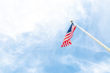 American flag flying high against blue sky