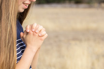 girl praying outdoors 