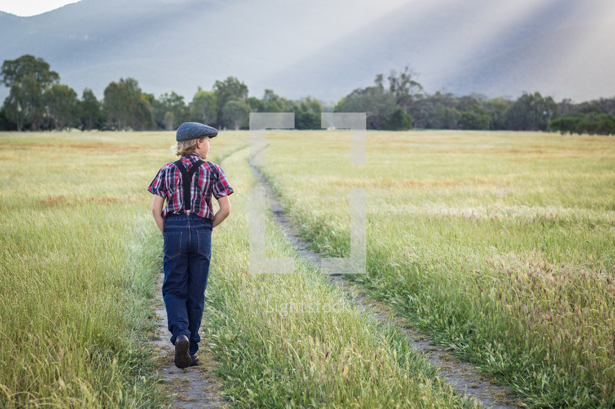 a young man walking in a field 