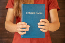 a girl holding a Baptist Hymnal 