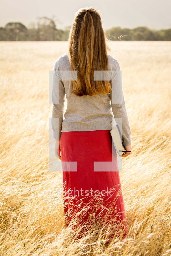 Girl Walking holding Bible
