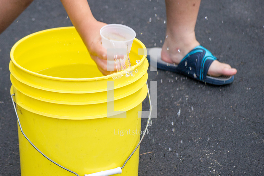 getting a cup of water out of a bucket 