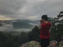 a child talking a picture on a mountaintop 