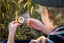 a boy looking at a compass