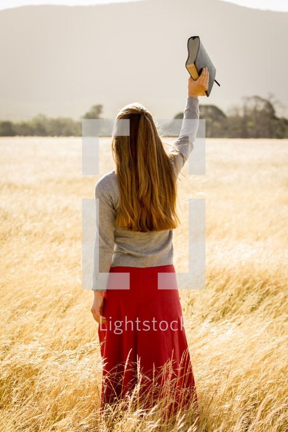 Girl Holding Bible in Air