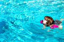 a girl child swimming in a pool