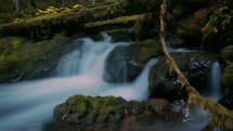 water flowing over moss covered rocks 