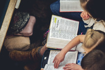 children reading Bibles during a worship service 