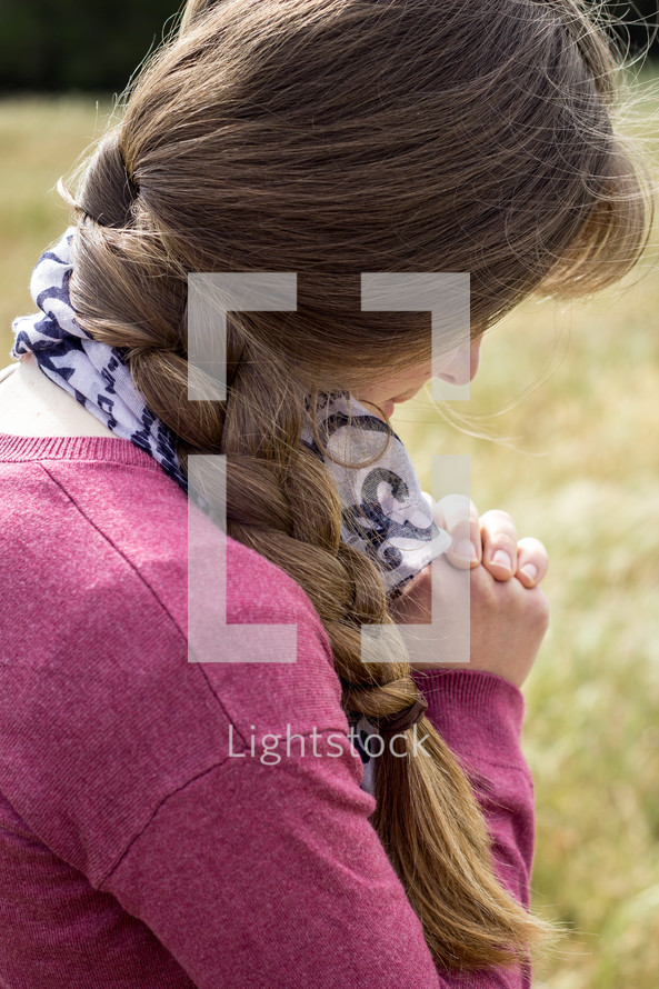 teen girl praying outdoors 