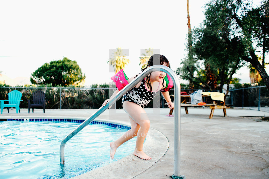 a child stepping out of a pool 