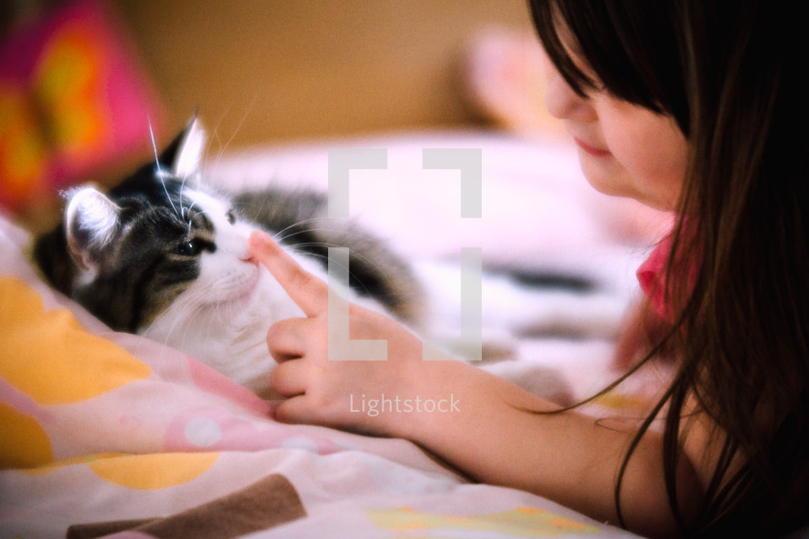 a little girl petting a cat 