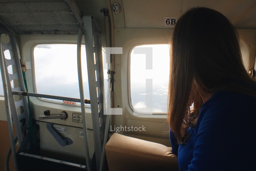 woman looking out a plane window 