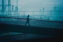 a man walking on a ramp in a foggy city 