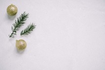gold glitter ornaments and pine needles in snow 