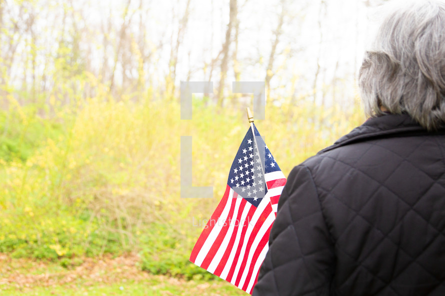 Woman holding American flag with yellow background