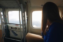 woman looking out a plane window 