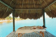 massage under a thatched roof on a dock 
