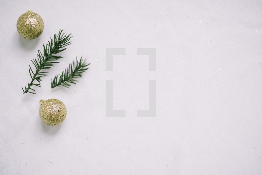 gold glitter ornaments and pine needles in snow 