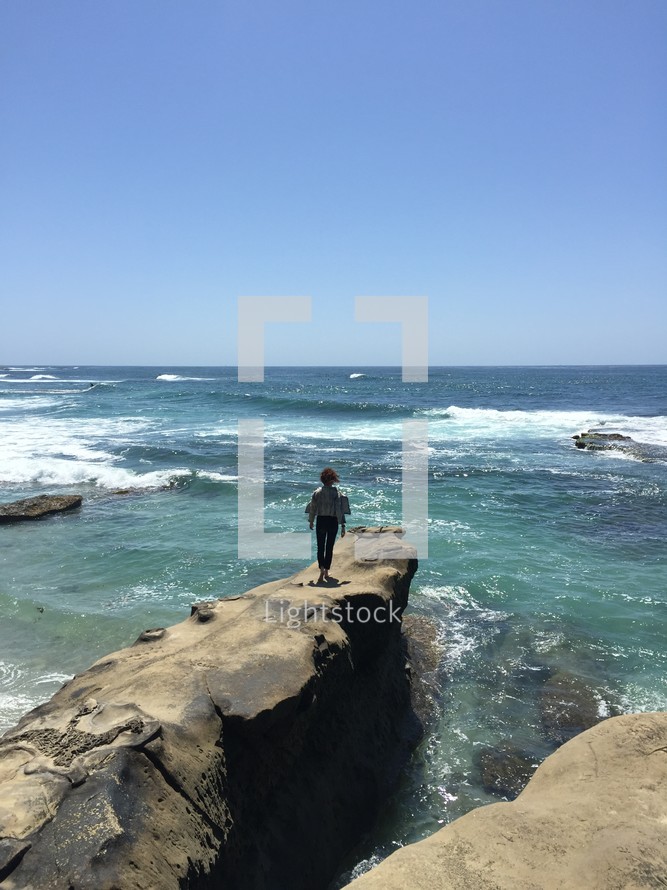 man standing on a rock over the ocean 