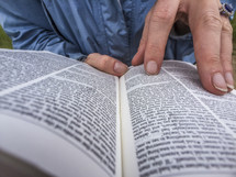 Close up of a woman holding an open Bible.