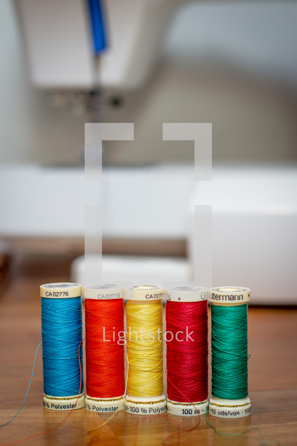 Row of Thread with Sewing Maching Background