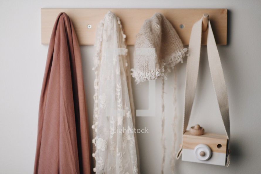 scarves, shawls, hats, and toy camera on hooks 