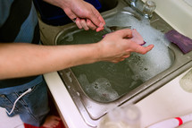 a man washing dishes at a sink 
