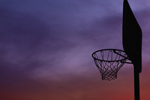 silhouette of a basketball goal at sunset 