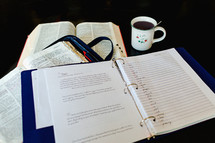 a list in a three ring notebook and an open Bible 