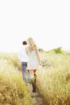 couple walking together on a path through a field