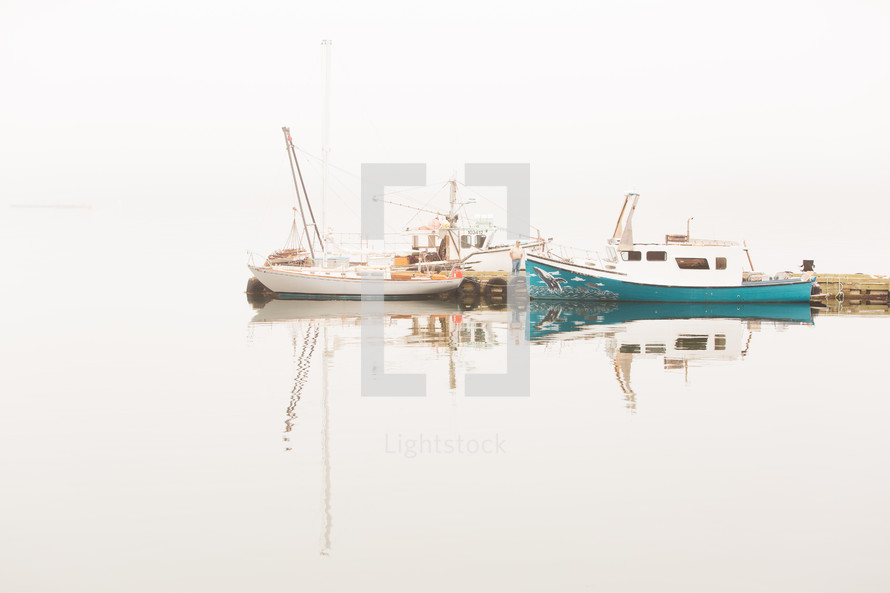 boats in a foggy bay 