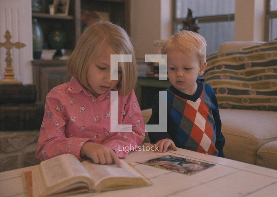 brother and sister reading reading a Bible together 