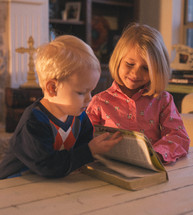 brother and sister reading a Bible together 
