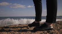 Woman legs standing on sandy beach