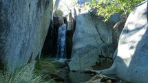 A small waterfall in a rocky desert canyon
