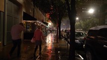 People walking downtown on a rainy night