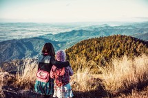 sisters hugging on a mountaintop 
