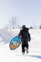 child running with sled 