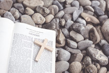 Bible open to Genesis lying on pebbles 