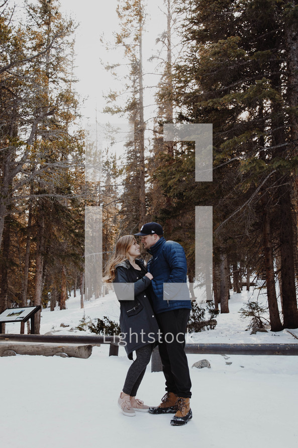 a couple kissing outdoors in snow 