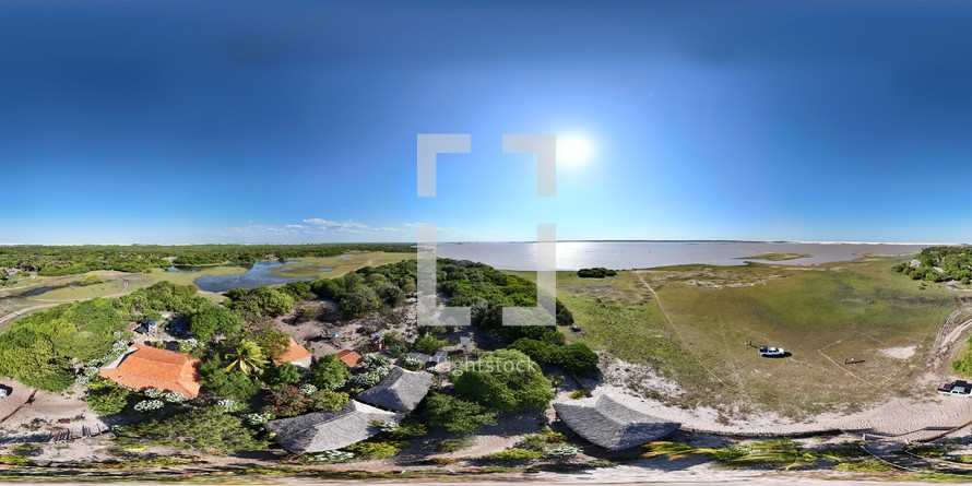 360 aerial photo taken with drone of restaurant next to river in Ponta Verde  in Lençóis Maranhenses National Park in northeast Brazil.