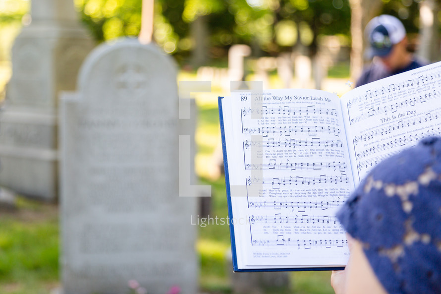 Holding a hymnal at cemetery