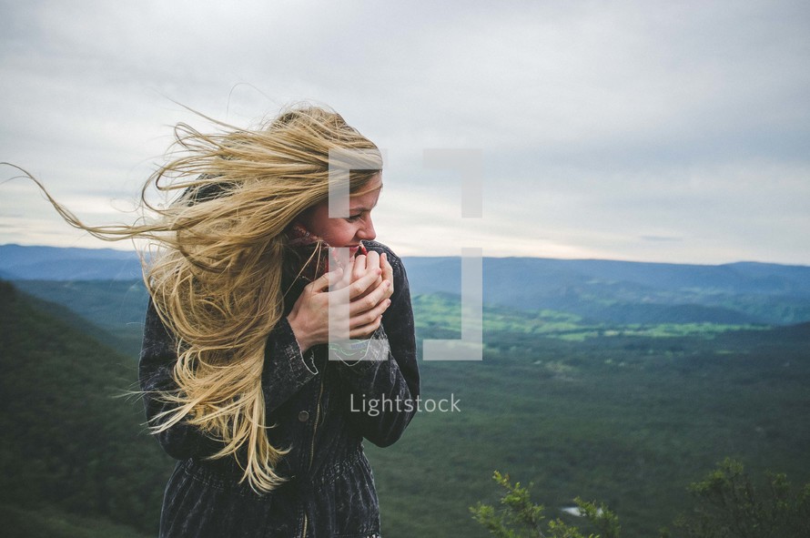 woman bundled up at the top of a mountain 