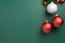 Hanging red and white colored Christmas baubles on a green background