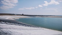 Large agricultural water reservoir surrounded by fields. Irrigation concept