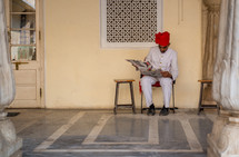 a man in India reading a newspaper 