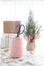 scissors, twine, gift boxes, and Christmas tree in snow 